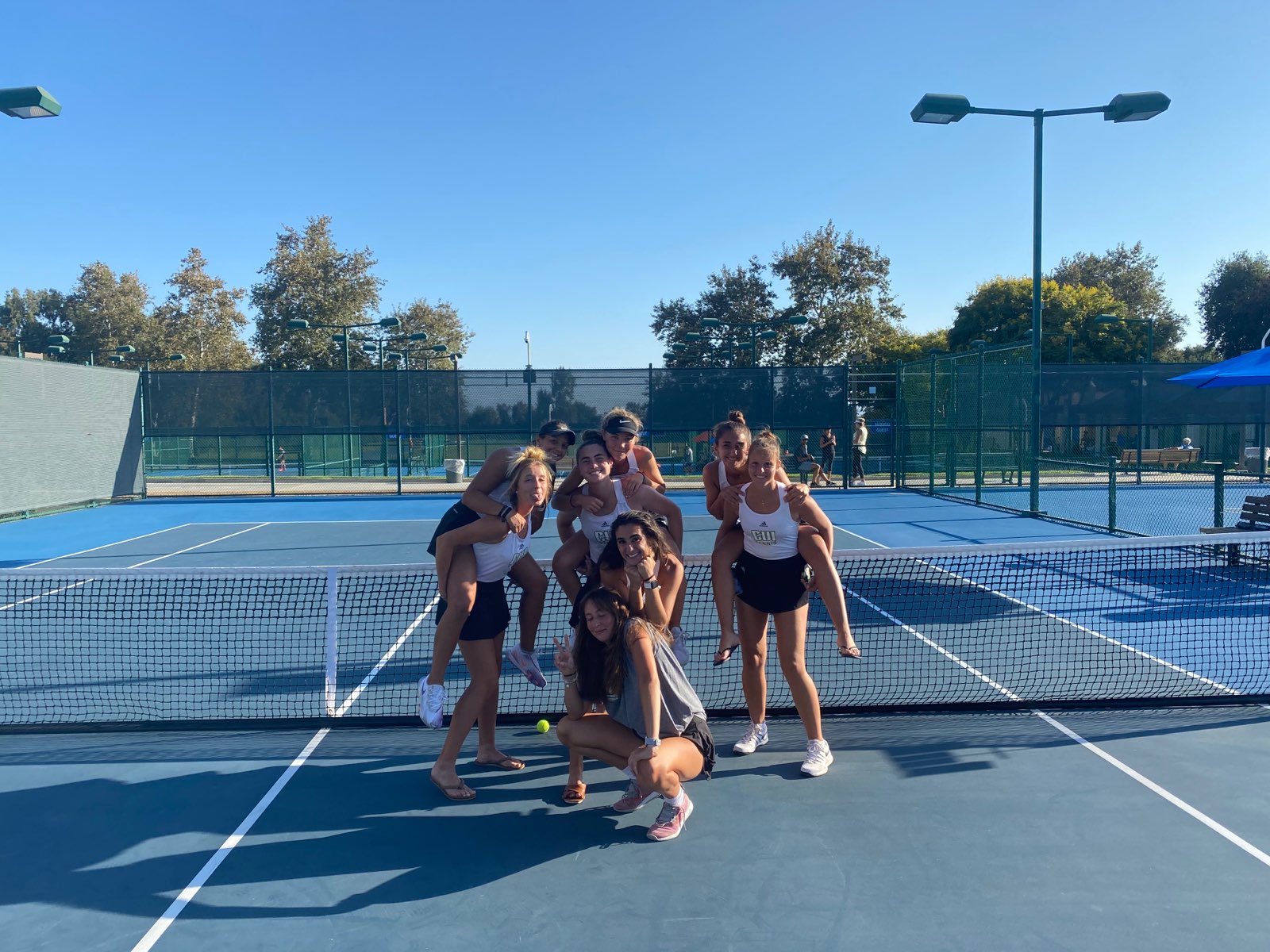 The women’s team poses after a practice at the tennis courts.